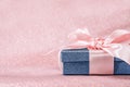 Blue sparkling gift box with pink ribbon on pink background