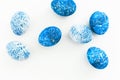 Blue Speckled Easter Egg with copy space for text on white background. Flat lay. Top view