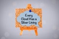 Blue paper speech bubble with phrase Every Cloud Has a Silver Lining on a corkboard