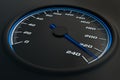 Blue speedometer in car on dashboard.