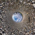 Blue sphere little planet inside gravel road and pebbles. curvature of space Royalty Free Stock Photo