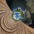 Blue sphere little planet inside transformation of wooden pier and lake Royalty Free Stock Photo