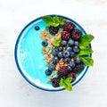 Blue Spirulina and Fresh Fruit Smoothie Bowl Topped with blackberries, blueberries, granola and yogurt. Breakfast.