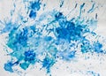 Blue splashes of watercolor paint on paper.