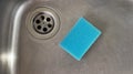 Blue sponge for washing dishes in the sink Royalty Free Stock Photo