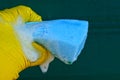 Blue sponge in foam in hand on a green background Royalty Free Stock Photo