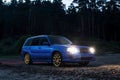 Blue sport wagon on the beach with the forest