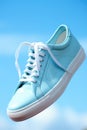 A blue sportive shoe with white laces flying in the air, AI