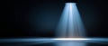 Blue spotlight beam shining down on empty dark stage floor with dramatic lighting and shadows Royalty Free Stock Photo