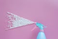 Blue spray bottle spraying white bubble foam on pink background with copy space. creative minimal for cleaning concept. Royalty Free Stock Photo