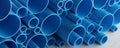 Blue stacked plastic PVC pipes for industrial construction, industry or water plumbing on concrete floor background