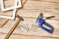 A blue stapler gun, staples and photo frames on a wooden table Royalty Free Stock Photo