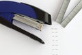 Blue stapler with staples and paper on the table Royalty Free Stock Photo