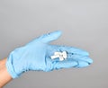 blue sterile gloved hand holding white pills Royalty Free Stock Photo