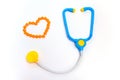 Blue stethoscope Isolated on white background. Medicine concept. Children`s toys by profession doctor. A heart is by orange pills Royalty Free Stock Photo