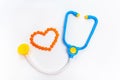 Blue stethoscope Isolated on white background. Medicine concept. Children toys by profession doctor. A heart is by orange pills Royalty Free Stock Photo