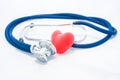Blue stethoscope and red heart lie on white homogeneous background. Concept photo of health or pathological condition of human hea Royalty Free Stock Photo