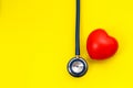 Blue stethoscope and red heart shape on yellow background. For c Royalty Free Stock Photo