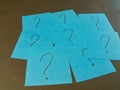 Blue Sticky Notes with Question Marks - Arrangement of blue sticky notes, each with a question mark, against a dark background. Royalty Free Stock Photo