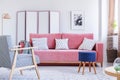 Blue stool next to pink couch in bright living room interior wit Royalty Free Stock Photo