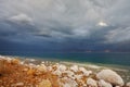 Blue storm cloud and rocks, overgrown with salt Royalty Free Stock Photo