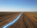 Blue streak of light on dirt road against clear sky Royalty Free Stock Photo