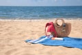 Blue striped beach towel with bag, swimsuit and accessories on sandy seashore, space for text Royalty Free Stock Photo