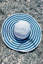 Blue striped sun hat on gray stones background. Royalty Free Stock Photo