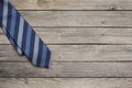 Blue striped tie over old wooden background as a concept for happy father`s day celebration Royalty Free Stock Photo