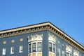 Blue stucco building with golden decorative facade with white accent paint around windows with flat roof and blue sky Royalty Free Stock Photo