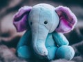 A blue stuffed elephant sitting on a bed. Generative AI image.