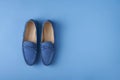 Blue suede man`s mocassin shoes over blue background