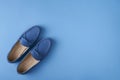 Blue suede man`s mocassin shoes over blue background