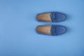 Blue suede man`s mocassin shoes over blue background