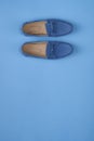 Blue suede man`s mocassin shoes over blue background