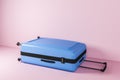 Blue suitcase lying in pink room