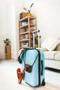 Blue suitcase with slippers, hat and camera.