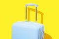 Blue suitcase on a yellow background with long deep shadows. Minimal style