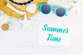 Blue summer time word on white card at wood table with sunglasses,straw hat,starfish,glass bottle top view,Vacation concept. Royalty Free Stock Photo