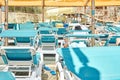 Blue sun loungers put in rows under transparent canopy Royalty Free Stock Photo