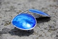 Blue sunglasses on the stone withe reflection from sun and clouds Royalty Free Stock Photo