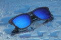 Blue sunglasses with water drops on water reflection Royalty Free Stock Photo