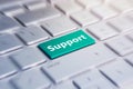 Blue support keyboard button. Green Button on Computer Keyboard. blurred in motion background. Royalty Free Stock Photo