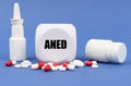 On the blue surface of the pill, capsule, spray, jar and cube with the inscription - ANED Royalty Free Stock Photo