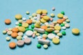 On the blue surface scattered multi-colored tablets, the concept of medicine and allergy Royalty Free Stock Photo