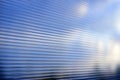 Blue surface of striped polycarbonate with a reflection of the blue distance of the city