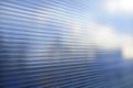 Blue surface of striped polycarbonate with a reflection of the blue distance of the city