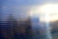 Blue surface of striped polycarbonate with a reflection of the blue distance of the city