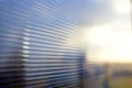 Blue surface of striped polycarbonate with a reflection of the blue distance of the city