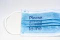 Blue surgical mask with the indication to maintain social distancing and not to stay so close. Covid-19 pandemic and social